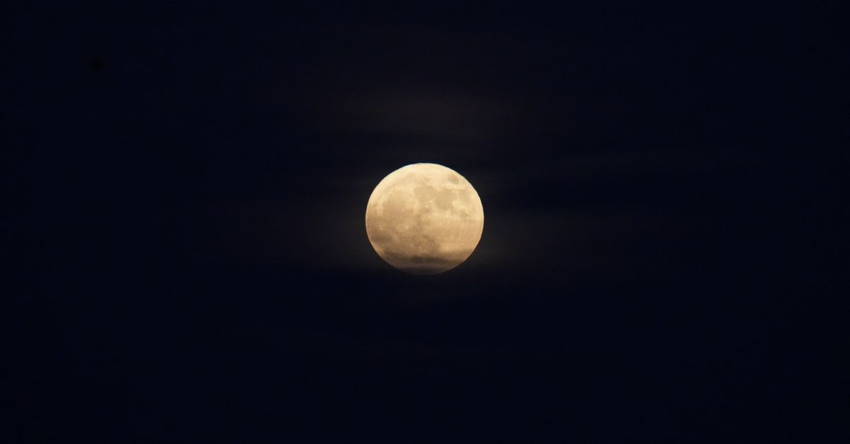 A luminous full moon surrounded by a dark, clear night sky, offering a serene celestial view.